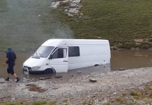 Microbuz plin cu turiști, blocat pe Transalpina într-o zonă cu apă și nămol