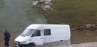 Microbuz plin cu turiști, blocat pe Transalpina într-o zonă cu apă și nămol