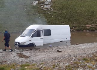 Microbuz plin cu turiști, blocat pe Transalpina într-o zonă cu apă și nămol